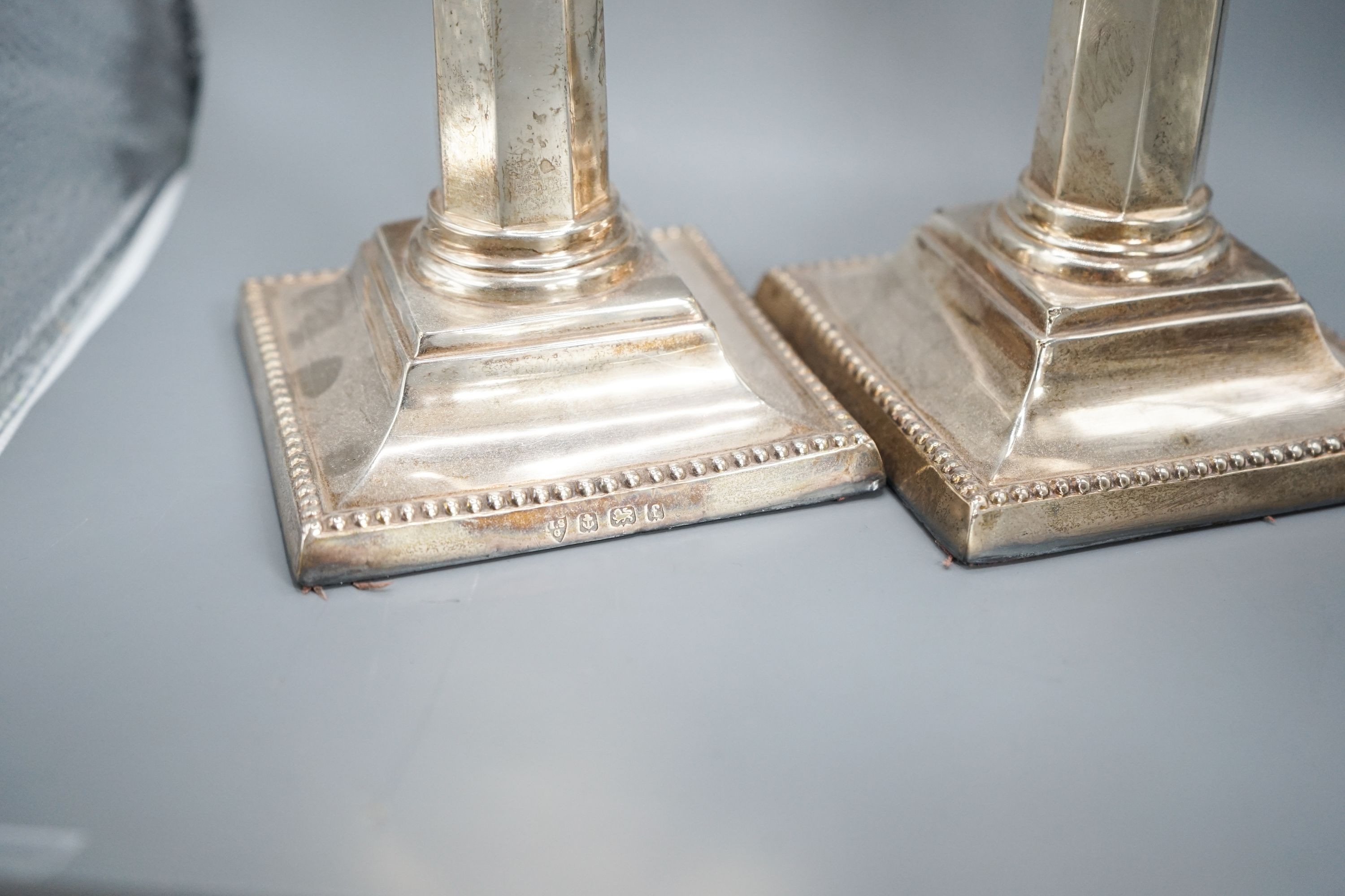 A pair of Edwardian silver candlesticks, with panelled columns, Birmingham, 1905, 20.8cm, weighted.